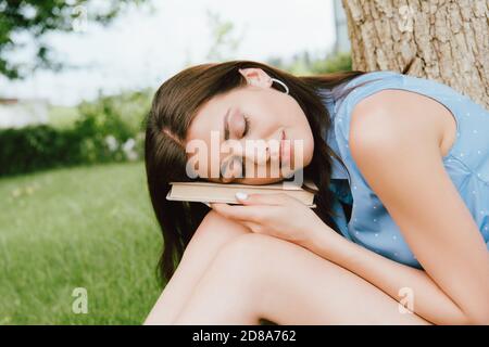 young and beautiful woman with closed eyes holding book Stock Photo