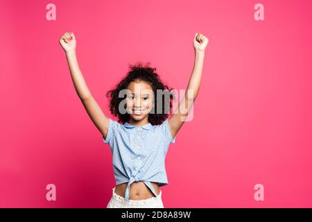 Happy cute african american preteen girl in casual outfit using modern ...