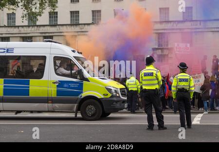 Peace for Armenia protest down Whitehall outside Downing Street. People setting off flares in front of police van. Focus on Police. London Stock Photo