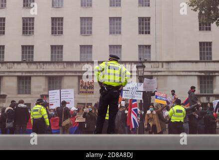 Peace for Armenia protest down Whitehall outside Downing Street. Police man on his own looking at protest. Focus on Police. London Stock Photo