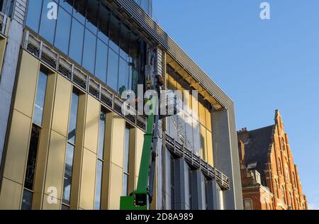 Building work with construction workers on a cherry picker on Charing Cross Road. London Stock Photo
