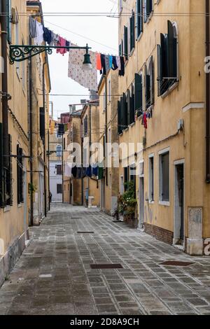 Washing hanging out to dry from homes in a narrow alley in the Castello region of Venice, Italy 2020 Stock Photo