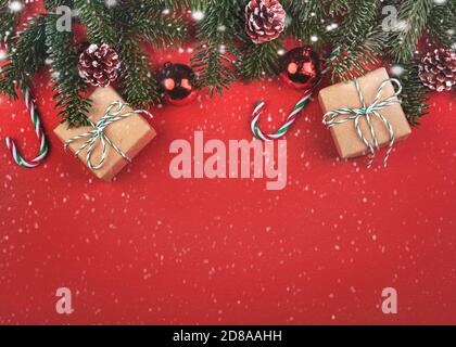 Merry Christmas.Christmas concept background.Christmas tree branches and Christmas with snowflakes over red background Stock Photo