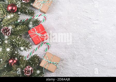Merry Christmas.Christmas concept background.Christmas tree branches and Christmas gifts with snowflakes over grey background Stock Photo