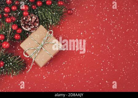 Merry Christmas.Christmas concept background.Christmas tree branches and Christmas gift with snowflakes over red background Stock Photo