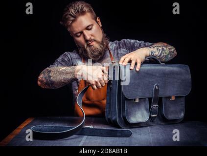 Professional Leather Worker works with leather at studio Stock Photo