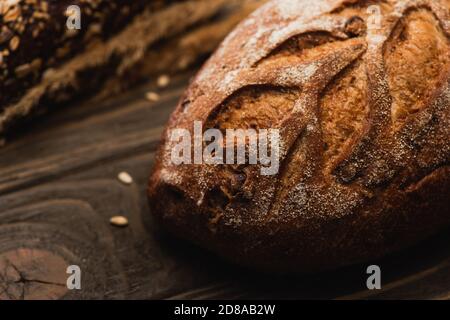 selective focus of fresh baked bread loaf on wooden surface Stock Photo