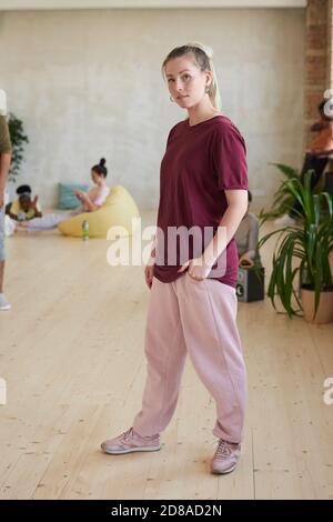 Portrait of female dancer in sports clothing looking at camera standing in dance studio Stock Photo