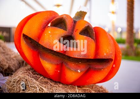 Jack-o-lantern smiling halloween pumpkin on a haystack, vivd orange color. Stock Photo