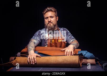 Leather master cutting out leather goods Stock Photo