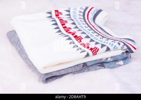 Warm winter knitted sweaters on white cozy background. Stock Photo