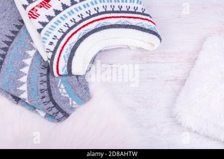 Warm winter knitted sweaters on white cozy background. Stock Photo