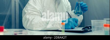 Scientist with protection suit investigating in the laboratory Stock Photo