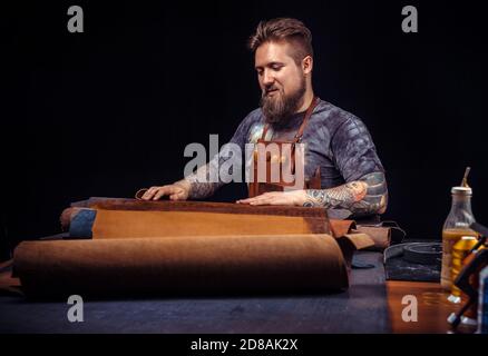Leather master working with leatherwork in a workshop Stock Photo