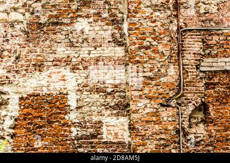 Old brick wall with traces of old restoration and reconstruction of the house. Abandoned house of the seventeenth century in the city center. Stock Photo