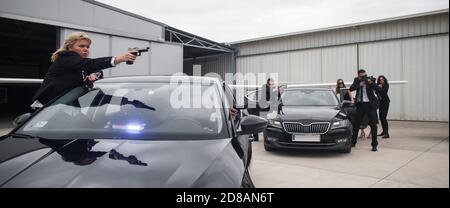 Famous female celebrity with bodyguards surrounded. VIP security agents and close protection officers Stock Photo