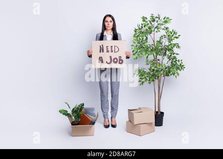 Full size photo of dismissed serious lady company crisis lost job hold carton placard ask job stand near stuff packs belongings fired ready move new Stock Photo