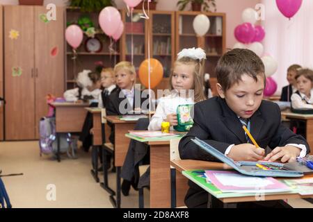 ST. PETERSBURG, RUSSIA-SEP 1, 2015: Primary school pupils sit on first lesson in school. Knowledge Day is the day when the school year traditionally s Stock Photo