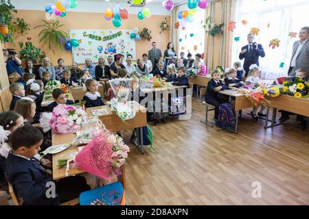 ST. PETERSBURG, RUSSIA-SEP 1, 2015: Primary school pupils with parents are on first lesson in school. Knowledge Day is the day when the school year tr Stock Photo