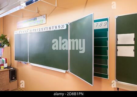 Green blackboard with Russian letters is on the wall in the classroom Stock Photo