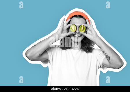 Young adult man covered eyes with kiwi Stock Photo