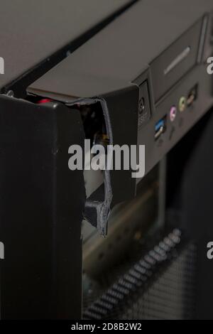 A closeup of the front of a broken computer. The case is black and is severely damahed.Room for text. Stock Photo