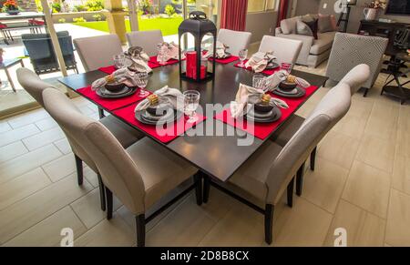 Square Dining Room Table With Eight High Back Chairs & Colorful Place Settings Stock Photo