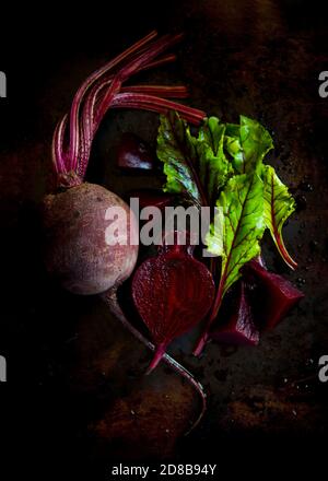 From above organic beetroots, foliage arranged on black background Stock Photo
