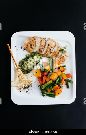 grilled duck with autumn vegetables on a black background Stock Photo