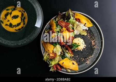 autumn salad with pumpkin and sun-dried tomatoes on a black background Stock Photo