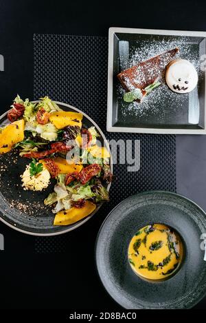 autumn salad with pumpkin and sun-dried tomatoes on a black background Stock Photo