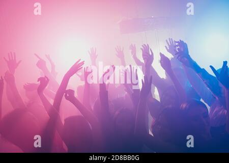 Photo of big group many people funky raise arms stage event concert floor neon bright pink spotlight modern club indoors Stock Photo