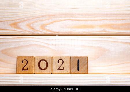 2021 text on wooden cubes on wood background, table. 2021 New Year abstract design concept. Closeup of wooden number block toy with 2021. Banner with Stock Photo