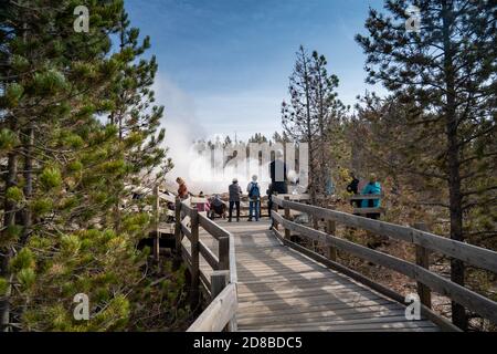 Wyoming, USA - September 23, 2020: A crowd of tourists gathers around Steamboat Geyser, the worlds largest geyser, in Yellowstone National Park, waiti Stock Photo