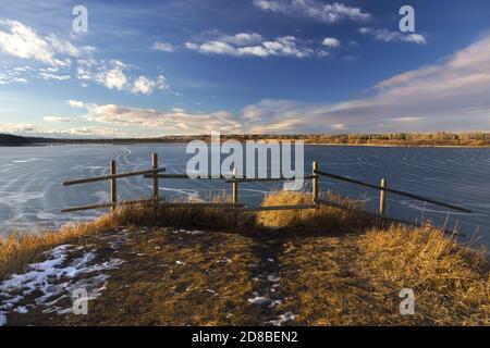 Wood Fence and Prairie Grass with Glenmore Reservoir Landscape Skyline. South Calgary, Alberta Foothills Public Park on a beautiful October Autumn Day Stock Photo