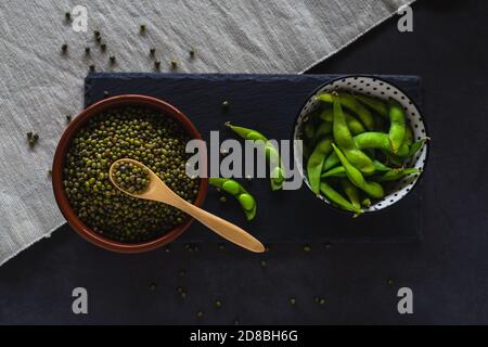 Bowls with mung beans and edamame pods. Green soybeans and healthy legumes. Stock Photo