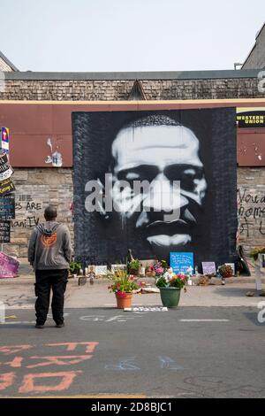 Minneapolis, Minnesota. African American man standing at the mural of George Floyd killed by police. Stock Photo