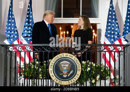 U.S President Donald Trump applauds U.S. Supreme Court Associate Justice Amy Coney Barrett from the Blue Room Balcony of the White House October 26, 2020 in Washington, DC. Stock Photo
