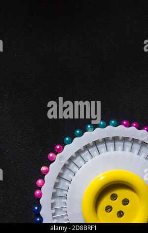 Set of colorful safety pins on black fabric background Stock Photo