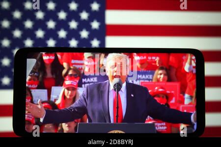 In this photo illustration, US President Donald Trump seen speaking during a campaign rally at Phoenix Goodyear Airport in Goodyear, Arizona on a live broadcast displayed on a smartphone screen. Stock Photo