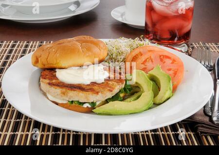 A turkey burger with avocado, tomatoes and sprouts Stock Photo