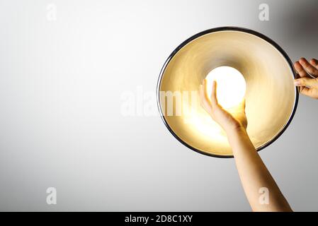 Electrician finished mounting ceiling lamp - installing a led lightbulb Stock Photo