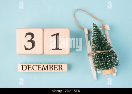 Waiting for the day concept. Top above close up view photo of small evergreen tree and wooden calendar showing the 31 of december isolated over light Stock Photo