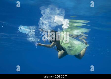 Snorkelers woman collects plastic debris that drifting on the surface of the blue ocean. Plastic garbage polluting seas and ocean
