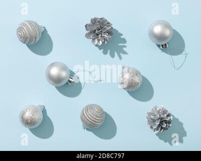 various silver color christmas decorations on blue paper background, top view, flat lay Stock Photo