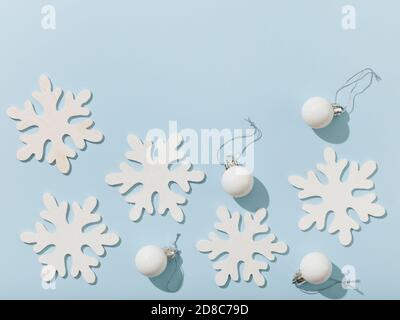 various white christmas decorations with shadows on blue paper background, top view, flat lay Stock Photo