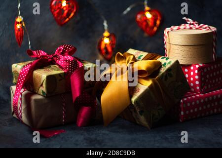 Christmas presents in red and natural colored paper on a dark background Stock Photo