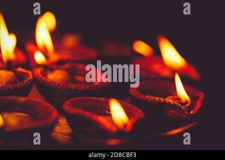 Diwali Diya, oil lamps lit or burning on the festive occasion of deepavali, deepawali. Background for Hindu ritualistic worshiping at temple, culture, Stock Photo