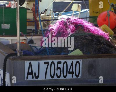 Brightly coloured fishing nets aboard a Corsican boat anchored in the harbour of Porto Pollo, Corsica, France
