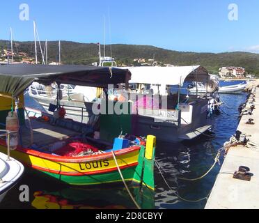 Brightly painted fishing boats anchored in the harbour of sleepy seaside village   Porto Pollo, Gulf of Valinco, Corsica France